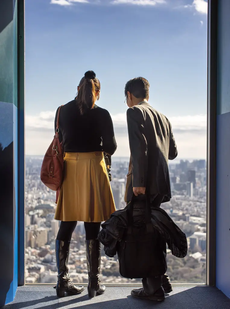 Two people looking at cityscape from high above. Image depicting below.