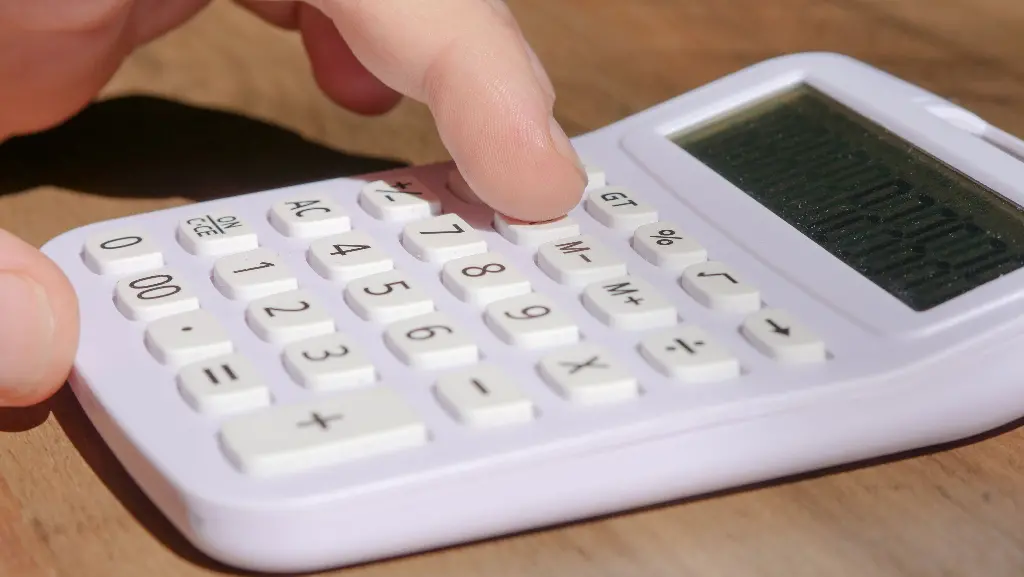 Child pressing buttons on a white calculator. Image depicting calculator.