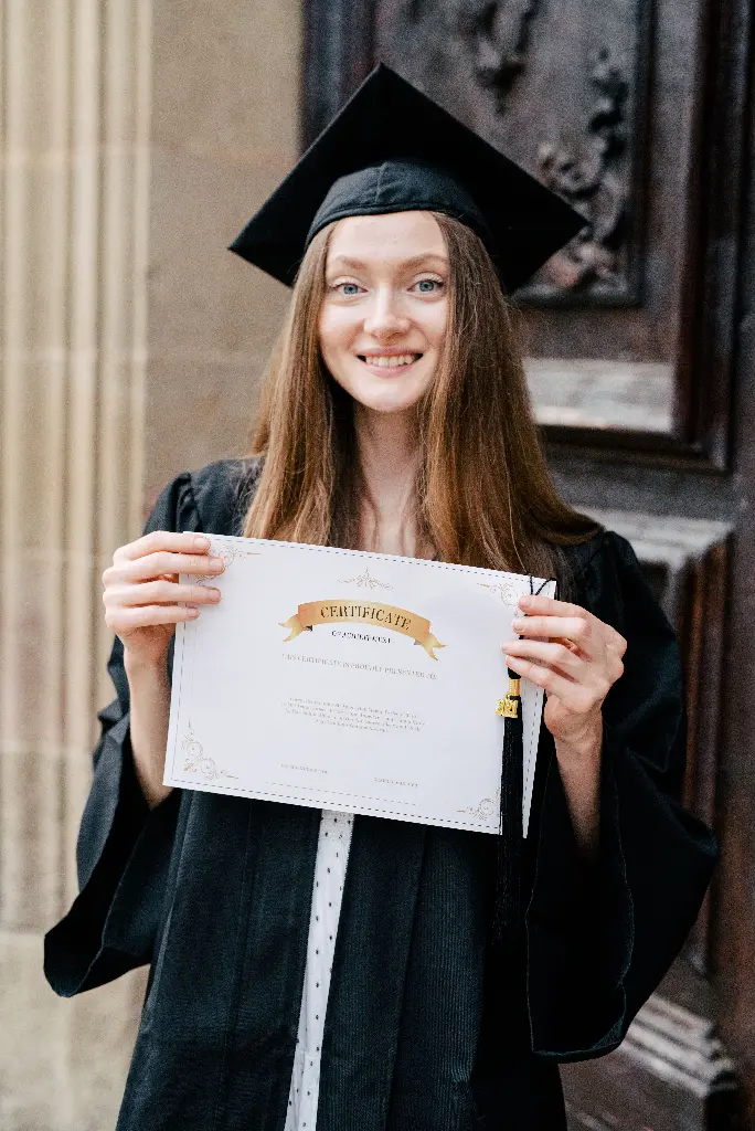Graduate holding a certificate in cap and gown Image depicting certificate.