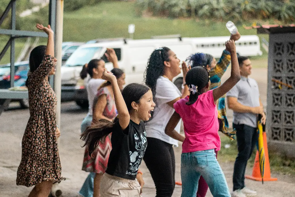 Group of excited children cheering outdoors. Image depicting excited.