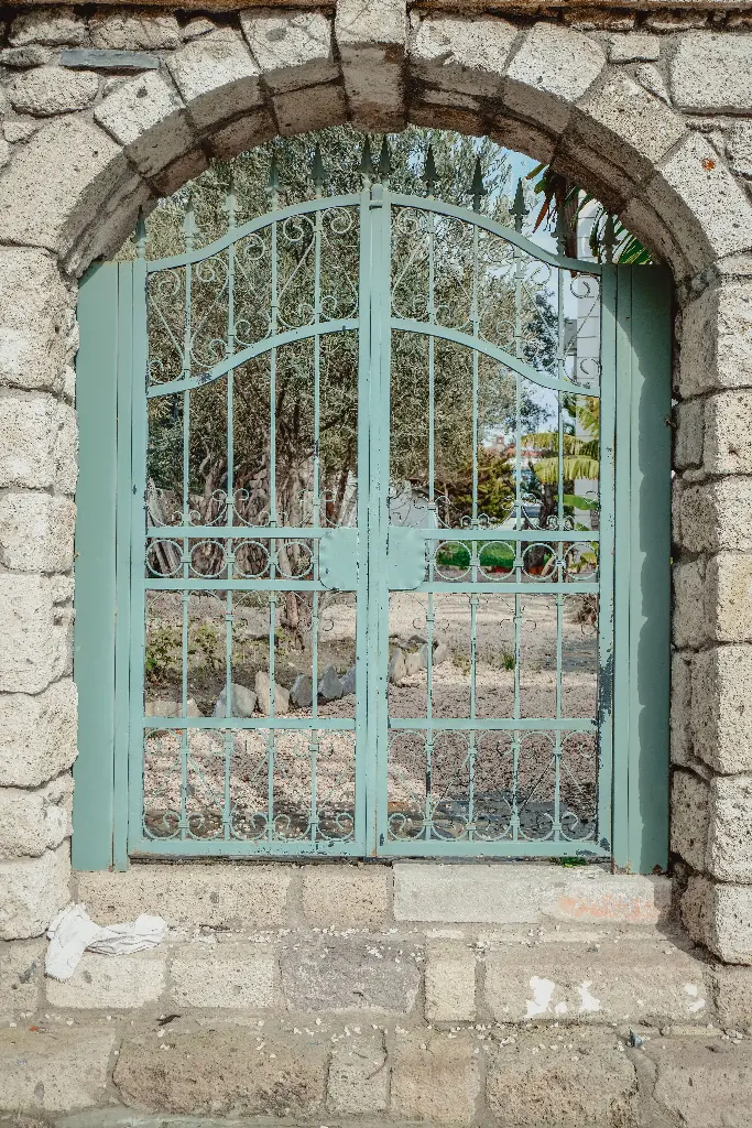 Stone archway with a decorative metal gate Image depicting gate.