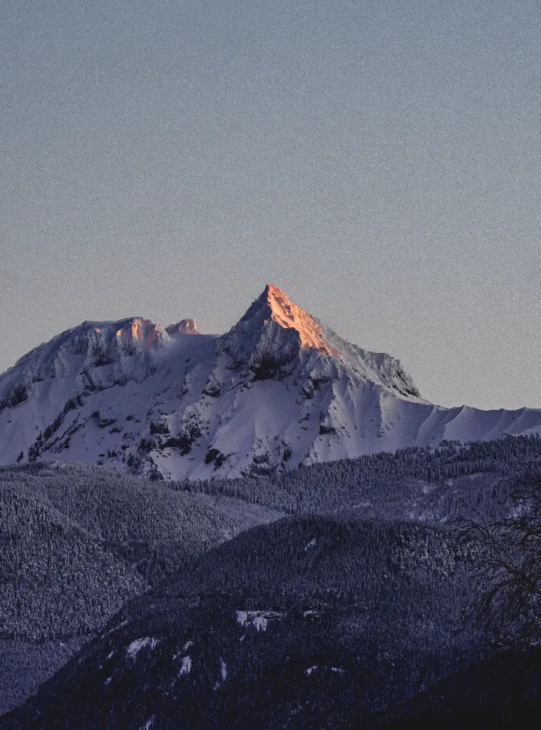 Snowy mountain peak glowing at sunrise. Image depicting mountain.
