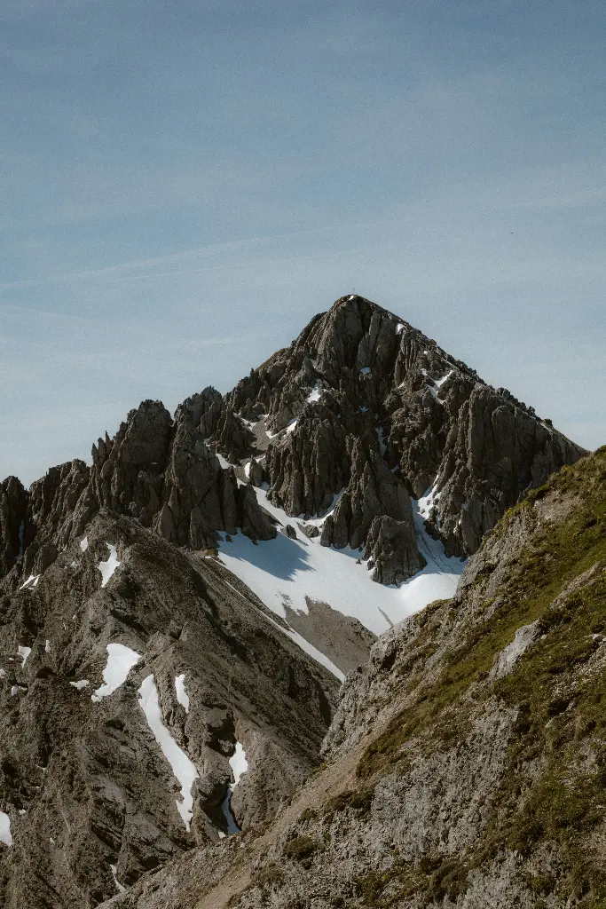 Snowy mountain peak under clear blue sky Image depicting peak.