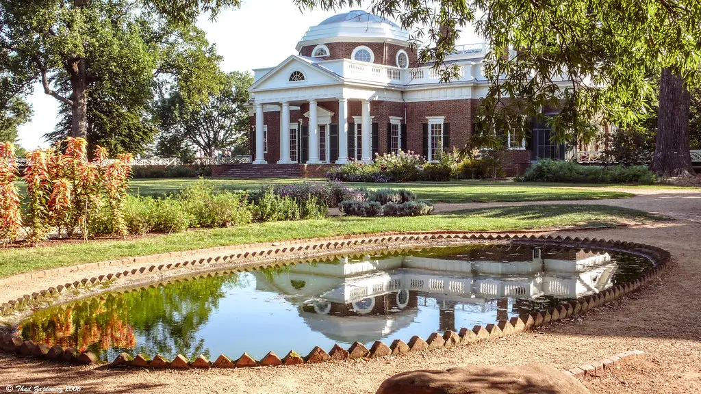 Beautiful pond reflecting a historic building and garden. Image depicting pond.