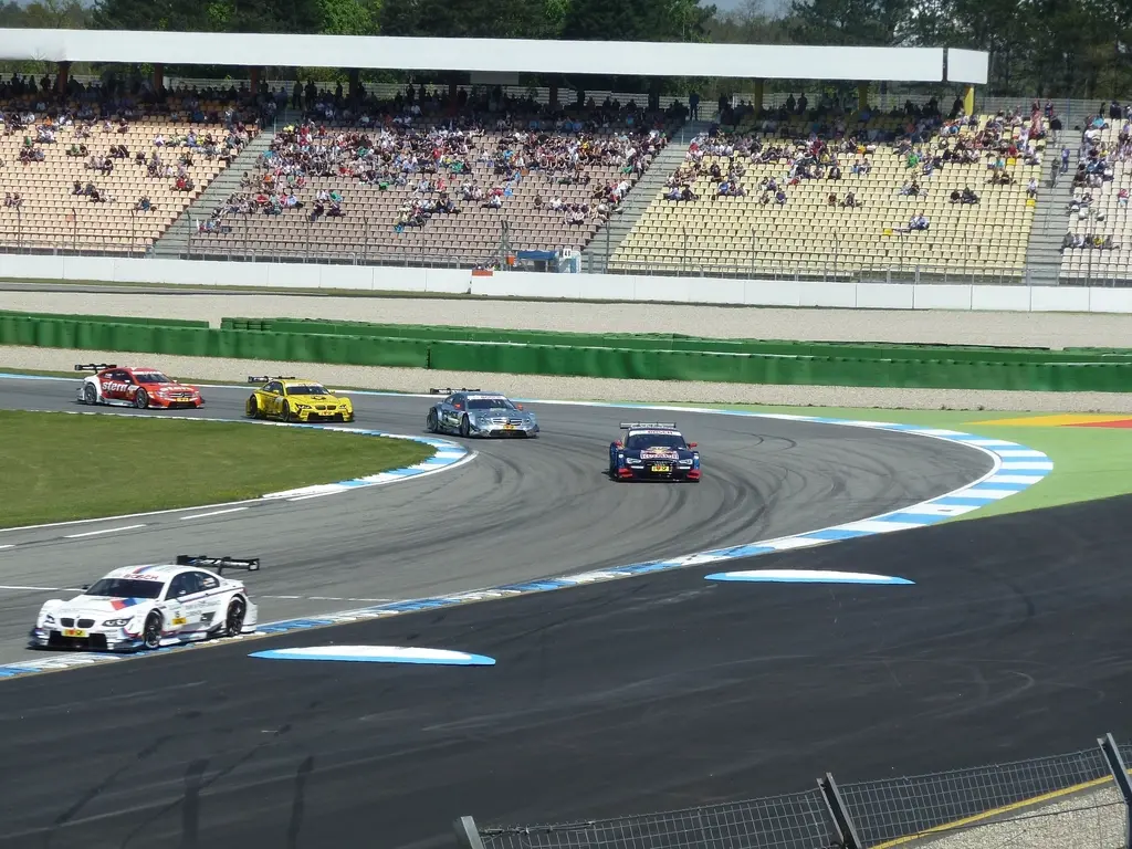 Cars racing on a track with spectators watching. Image depicting race.