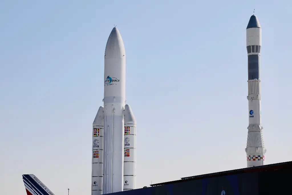 Two tall rockets standing on a launch pad. Image depicting rocket.