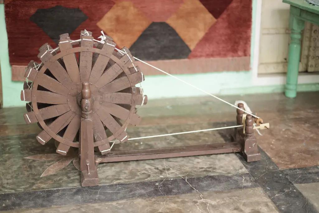 Wooden spinning wheel used to rotate thread. Image depicting rotate.