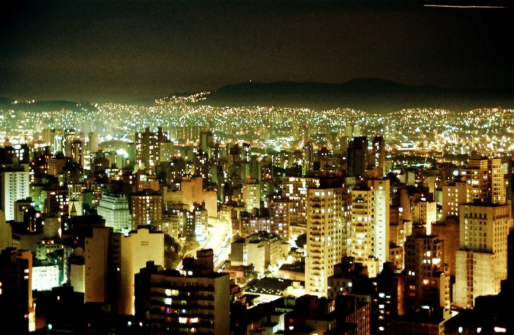 City skyline with skyscrapers illuminated at night. Image depicting skyscrapers.
