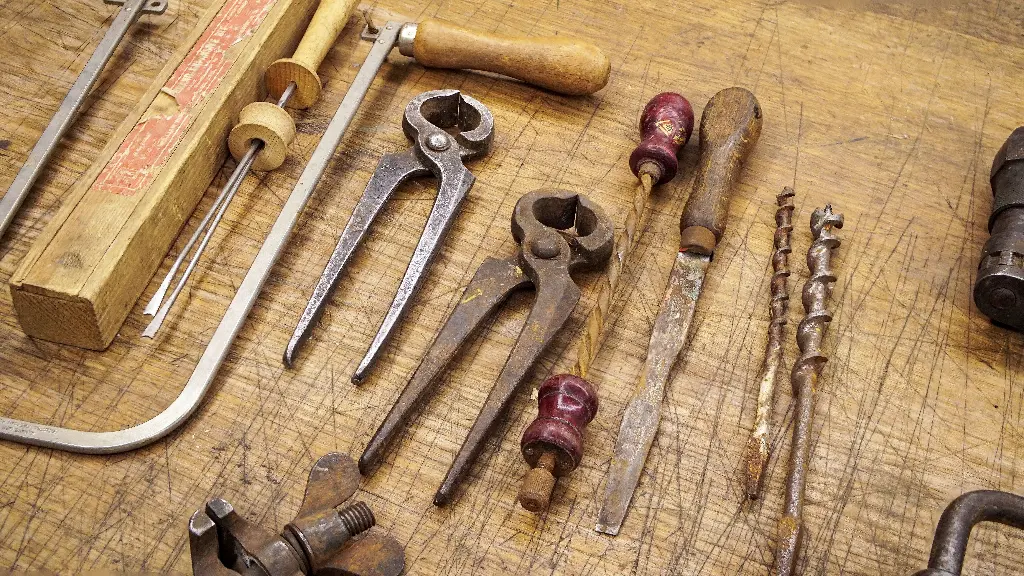 Various old tools on a wooden workbench. Image depicting tools.